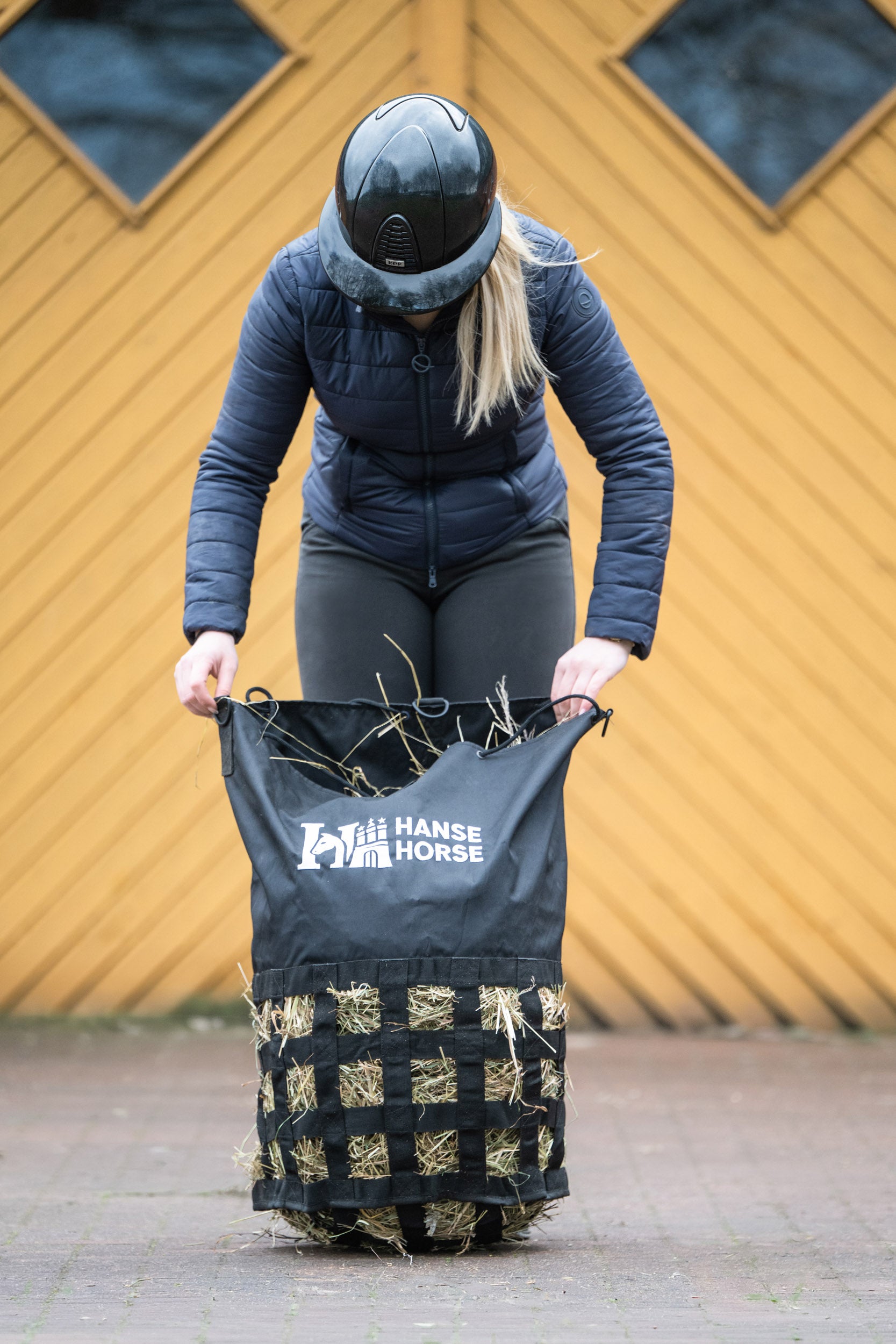 HanseHorse Heunetz Größe M wird für Slowfeeding mit Heu befüllt
