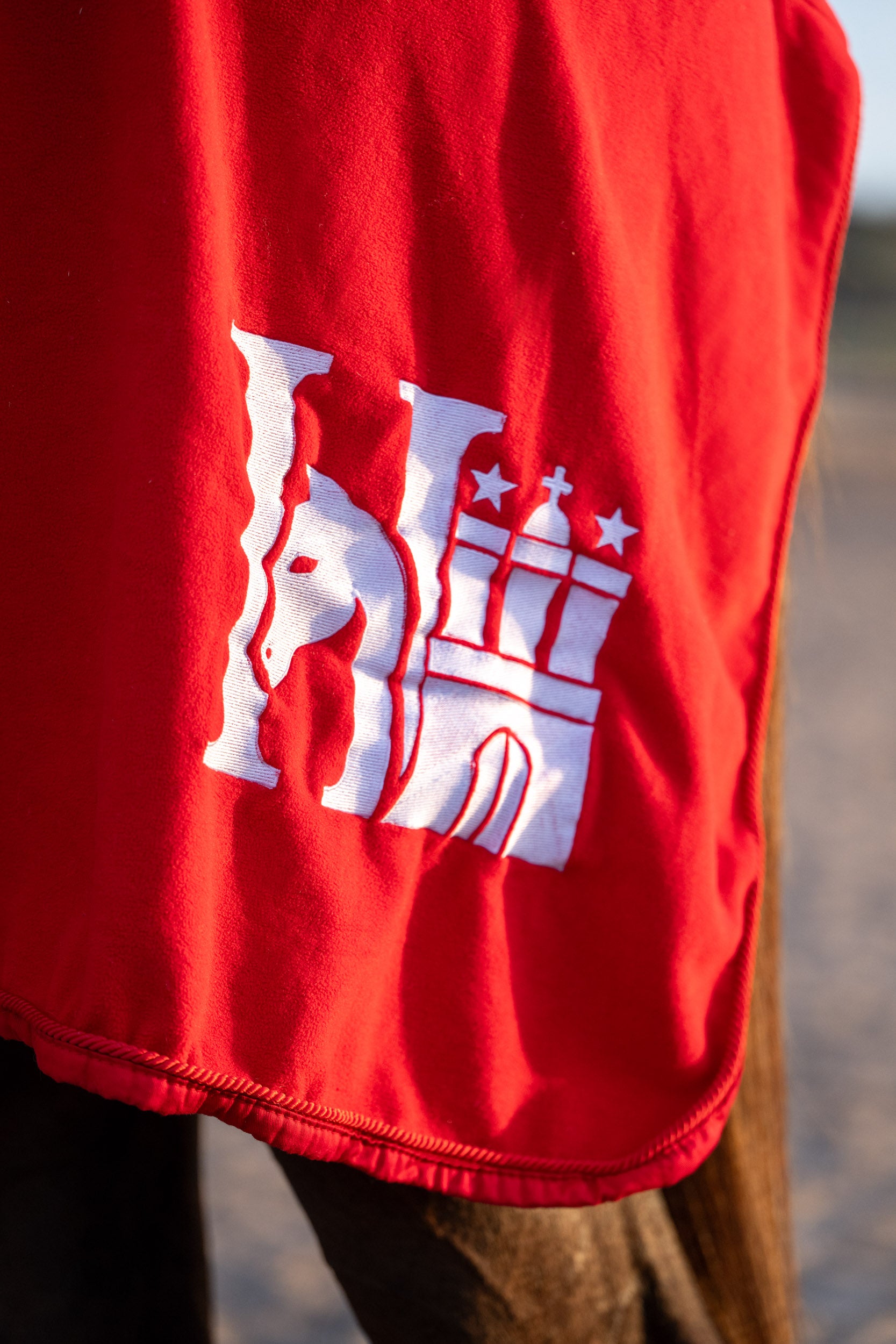 Logo-Detail auf der HanseHorse Pferdedecke in Regatta Red
